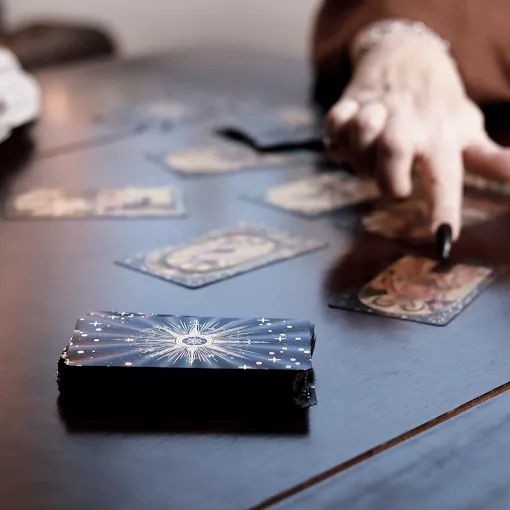Ausgebreitete Tarotkarten als Fächer auf einem Holztisch